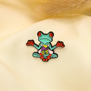 Detail of creative meditating frog enamel pin with anatomical colorful organ design
