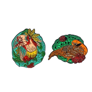 Artistic tropical toucan and colorful bird enamel brooches with lush green leaves