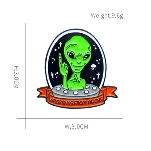 Detail of alien enamel pin showing Greetings from Aliens text and 3.0cm dimensions