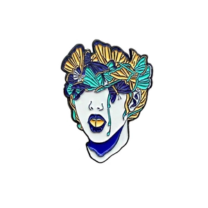 Broche en émail artistique avec des papillons colorés sur un portrait de visage de sorcière
