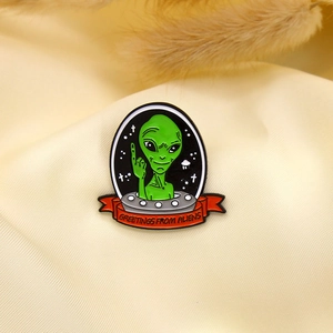 Creative alien in silver UFO enamel brooch with Greetings from Aliens text on yellow silk