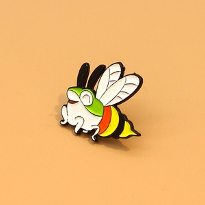 Detailed macro view of creative enamel frog bee fusion brooch pin with green and yellow oil drip