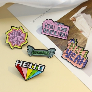 Five-piece set of colorful enamel pins featuring motivational phrases like You Matter