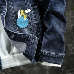 Emaille-Brosche mit Polarbär-Motiv an einer Jeansjacke mit weicher Beleuchtung