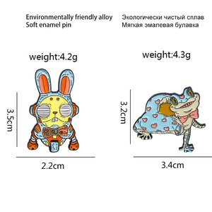 Macro detail of alloy enamel pins showing rabbit astronaut and frog with dimensions