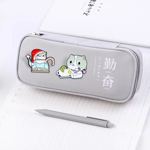Gray canvas pencil case with cat enamel pins and Diligent Student text on front