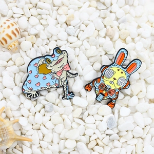 Cartoon enamel pins set featuring a blue frog in heart cape and a mechanical yellow rabbit