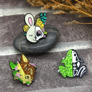 Unique Halloween enamel pins set featuring skeletal animal designs on textured grey stone
