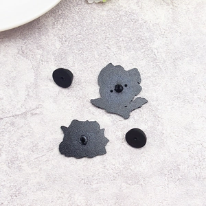 Detail view of the black metal brooch back with textured finish and secure rubber clutch