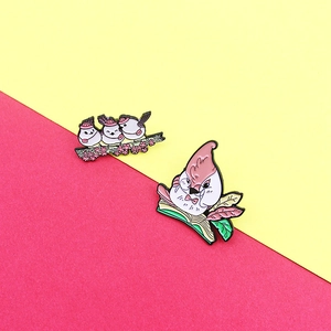 Cartoon enamel bird pins featuring mother bird reading and small birds on a cherry branch