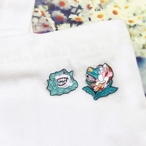 Creative enamel floral shark and wolf lapel pins on a white canvas bag accessory