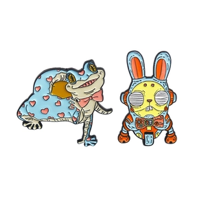 Cartoon enamel lapel pins featuring a blue robot bunny and a heart-pattern frog badge