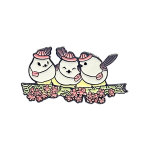Detail of cartoon white birds with pink hats on a floral branch enamel brooch