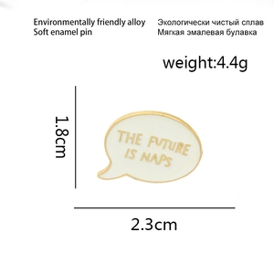 Detail of round soft enamel pin with gold lettering THE FUTURE IS NAPS slogan