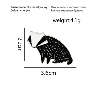 Detailed size view of black and white badger enamel pin measuring 3.6cm by 2.2cm