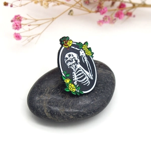 Broche gothique en émail avec tête de mort, roses jaunes et cloche sur pierre grise