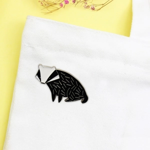Cute black and white badger enamel pin badge on a white canvas bag with yellow background