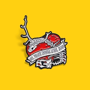 Broche en émail détaillée avec cœur rouge, crâne de cerf et texte sur ruban romantique