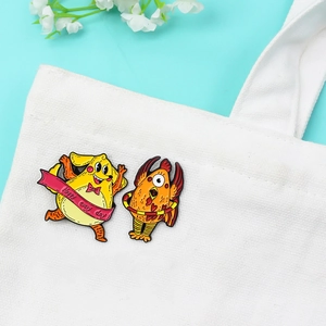 Gros plan de pin's en émail coq et chien sur sac en toile avec fond bleu clair