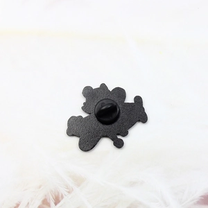 Detail view of cartoon character enamel pin back with secure black rubber clutch on metal