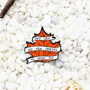 Maple leaf enamel brooch with Lorien quote on white stones minimalist product photography