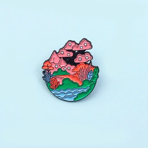 Close-up of circular enamel landscape brooch featuring cherry trees and flowing river