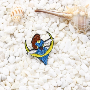 Broche en émail d'une fille en robe bleue sur une lune jaune avec des nuages blancs
