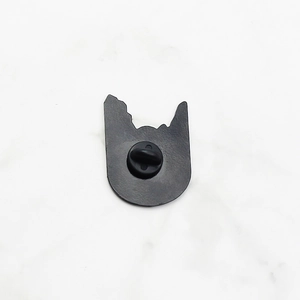Detail of matte black enamel brooch back featuring a secure rubber pin clutch