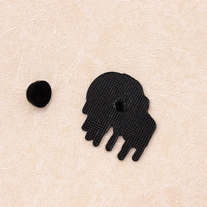 Détail du revers d'une broche crâne punk en alliage avec texture grillagée et fermoir