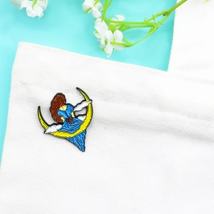 Broche en émail d'une fille en robe bleue sur la lune avec des nuages blancs