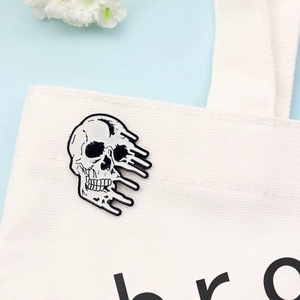 Insigne créatif tête de mort fondu style punk en émail sur un sac en toile blanc