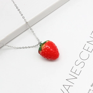 Collier à pendentif fraise 3D tendance avec chaîne argentée sur fond blanc