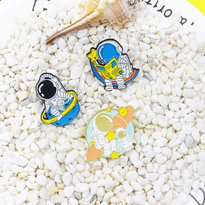 Set of cartoon astronaut enamel pins with space exploration designs on white stones