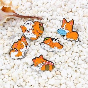 Cute cartoon enamel pins featuring sleeping angel cats and playful corgi dogs on pebbles