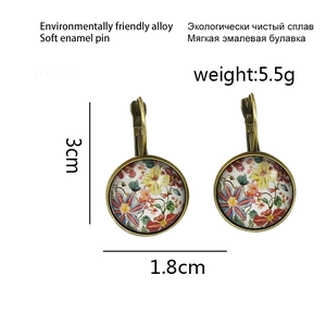 Detail view of vintage lever-back flower earrings featuring red floral patterns