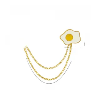 Macro shot of cartoon fried egg and EAT ME speech bubble linked by gold chains
