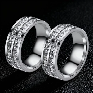 Close-up of silver-tone stainless steel rings set with rows of square clear stones