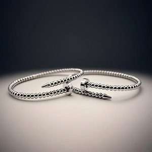 Dettaglio ravvicinato di un bracciale in acciaio al titanio a forma di chiodo perlato
