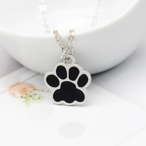 Minimalist silver animal paw pendant necklace with black enamel inlay on a fine chain