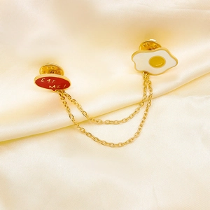 Whimsical poached egg enamel chain brooch with Eat Me text on satin backdrop
