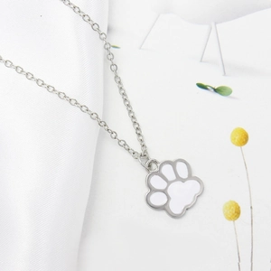Minimalist silver chain necklace with a cute white enamel paw print pendant