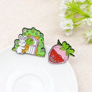 Ensemble de broches mignonnes lapin, carotte et fraise sur une assiette blanche