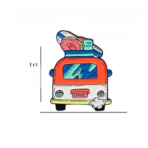 Detail view of cartoon travel bus brooch with surfboard and donut on white background