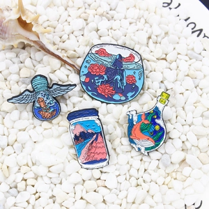 Set of four creative enamel pins featuring whale, mountain bottle, and angel bulb motifs