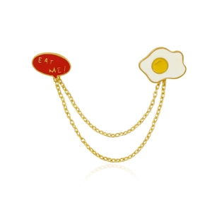 Cartoon fried egg chain brooch with red Eat Me dialog box and golden finish