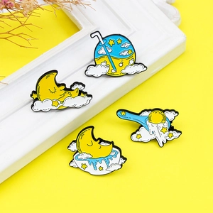 Cartoon enamel pin set featuring a sleeping moon on a cloud with yellow and blue stars
