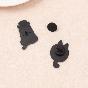 Cartoon hippo and cat enamel pins with secure black rubber backings on pink surface