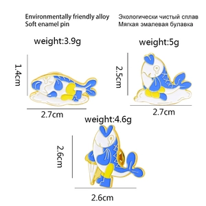 Trois pin's de requin en émail coloré bleu et jaune avec dimensions et poids affichés