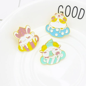 Trois broches en émail mignonnes avec lapin, hamster et mouton dans des tasses à café