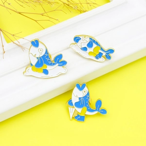 Lot de trois broches en émail représentant des carpes koï avec parapluies sur fond jaune